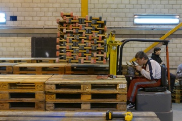 Christian Brodbeck zielt durch eine der Palettengassen.