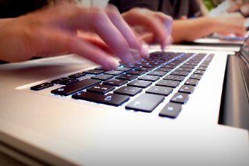 Flink tippt die Sekretrin den Versammlungsverlauf in den Mac.